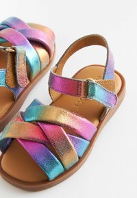 Sandales pour enfants avec brides métalliques multicolores, semelle intérieure matelassée beige et semelle extérieure marron sur fond blanc.