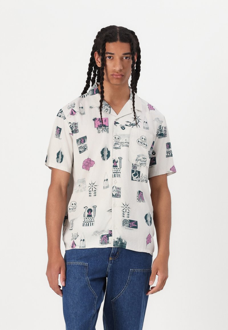 Short-sleeve button-up shirt in light fabric featuring a variety of graphic prints in blue, pink, and black on a cream background.