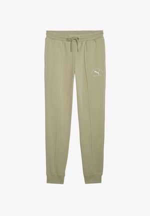 Svetložlté športové tepláky s nastaviteľným pásom, elastickými manžetami a malým bielym logom na boku. Mäkká, hladká textúra tkaniny.