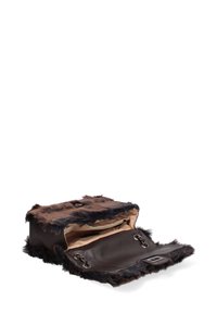 Borsa in finta pelliccia e pelle, di forma rettangolare, marrone con accenti neri, aperta per rivelare un interno marrone e compartimenti. Superficie texturizzata.