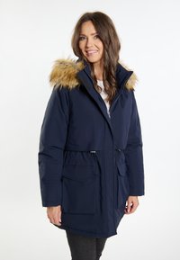 Mørkeblå puffjakke med en faux fur hætte, snore i taljen og forlommer. Glat tekstur med metallisk lynlås og accentdetaljer.