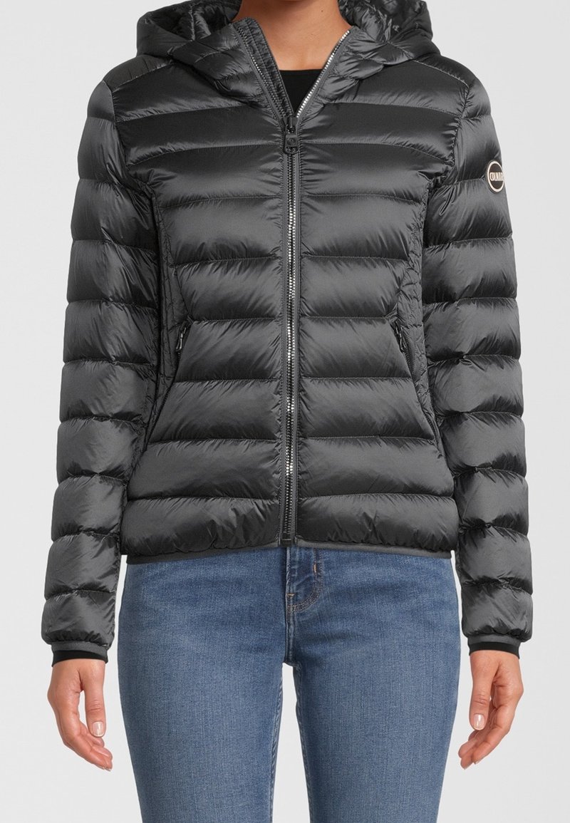 Svart puffjacka med huva, med dragkedja fram, baffeldesign och sidofickor. Tillverkad av glänsande, slätt material.