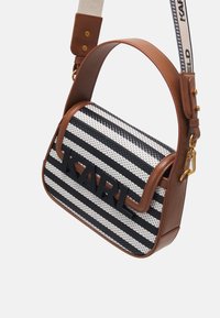 Brun väska med läderdetaljer, svartvita vävda ränder, stora svarta bokstäver "KARL" och justerbar beige axelrem i tyg med metallbeslag.