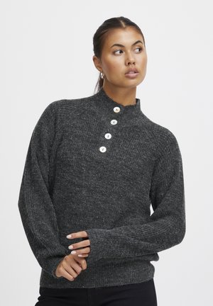 Maglione lavorato a maglia grigio scuro con collo alto, quattro grandi bottoni al colletto e polsini a coste. Tessuto morbido e vestibilità rilassata.