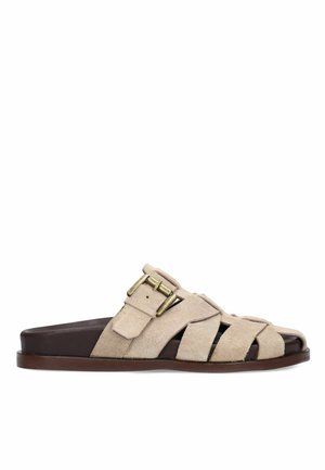Beige suede slip-on sandal with multiple straps, open toe, and an adjustable gold-toned buckle on a dark brown sole.