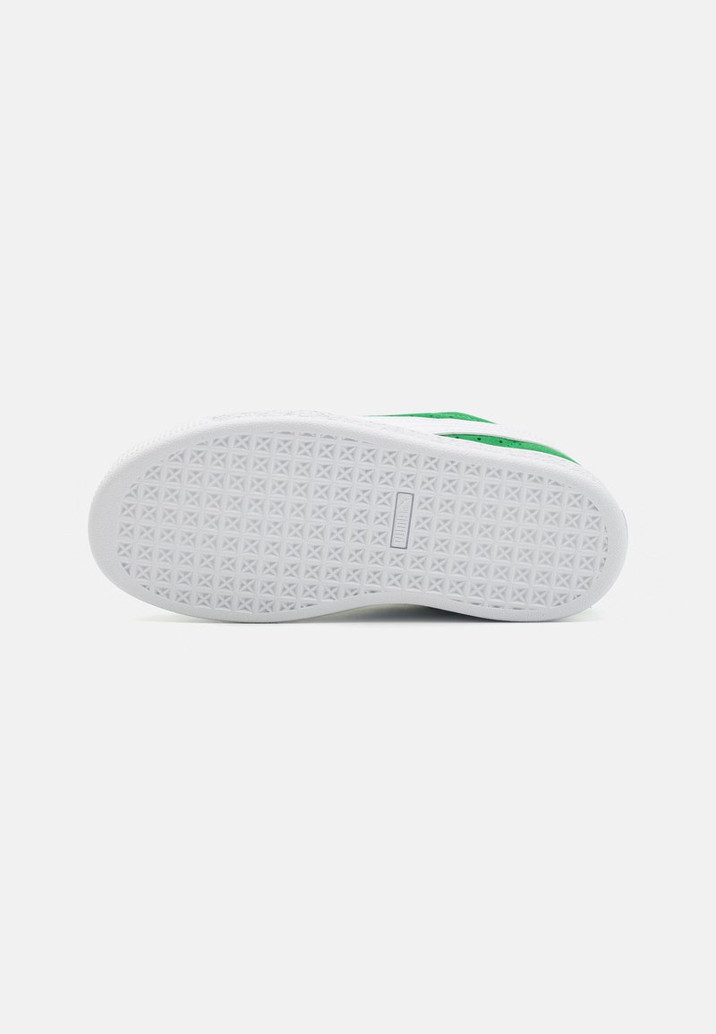 Semelle en caoutchouc plate avec un motif texturé. Présente des accents verts sur le côté et un design épuré.