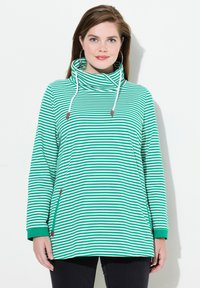 Pullover a righe verde e bianche con collo a imbuto, maniche lunghe e polsini a coste. Presenta lacci decorativi e accenti laterali.