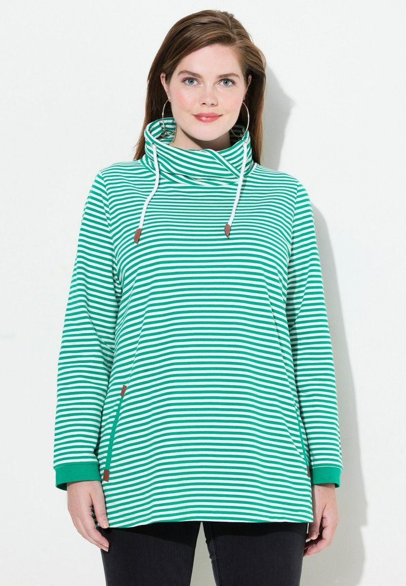 Pullover a righe verde e bianche con collo a imbuto, maniche lunghe e polsini a coste. Presenta lacci decorativi e accenti laterali.