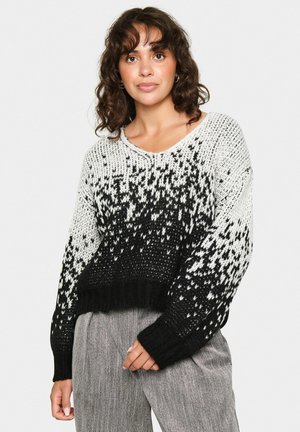Schwarzer und weißer Strickpullover mit V-Ausschnitt, lockerer Passform und einem Farbverlaufmuster. Gerippte Bündchen und Saum verstärken die Textur.