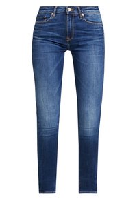 Jeans ajustados de mezclilla azul oscuro con textura desgastada, que cuentan con cinco bolsillos, cierre de botón metálico y detalles de costura en contraste.