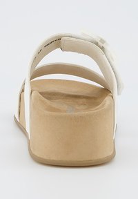 Plateau-sandalen met een beige zool, witte verstelbare bandjes en een textiel aan de hiel. Minimalistisch ontwerp met zachte randen.