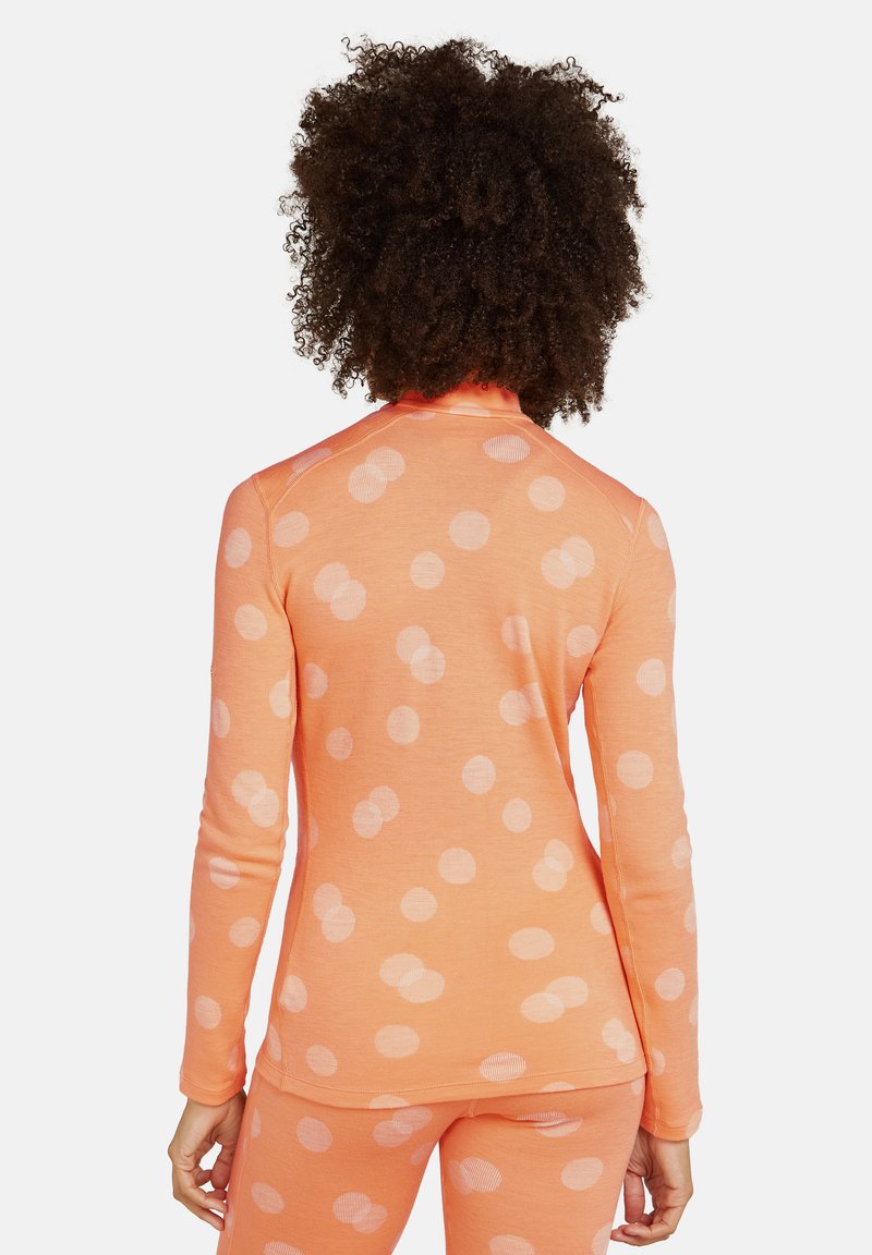 Oranges Langarmshirt mit weißen Punkten, das ein tailliertes Design und eine gerippte Textur aufweist, von hinten gezeigt.