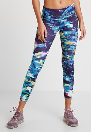 Leggings colorés à motifs en violet, bleu et vert. Fabriqués en matière extensible, conçus pour un usage athlétique, avec une taille haute.