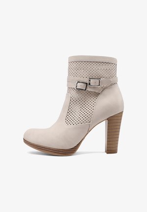 Stivaletto beige in suede con alto tacco in legno a blocco, sezione superiore traforata e due cinturini regolabili con fibbie d'argento.