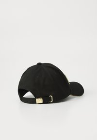 Boné de basebol preto com fivela de metal dourado e faixa ajustável, exibido de trás em um fundo branco.