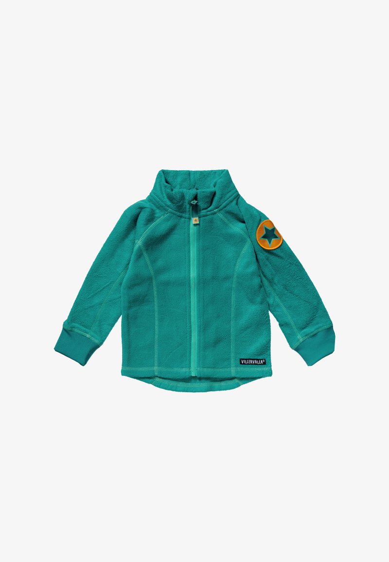 Turkusowa kurtka z polaru z wysokim kołnierzem, przednim zamkiem błyskawicznym i ściągaczami przy mankietach. Na lewym ramieniu znajduje się pomarańczowa naszywka w kształcie gwiazdy.