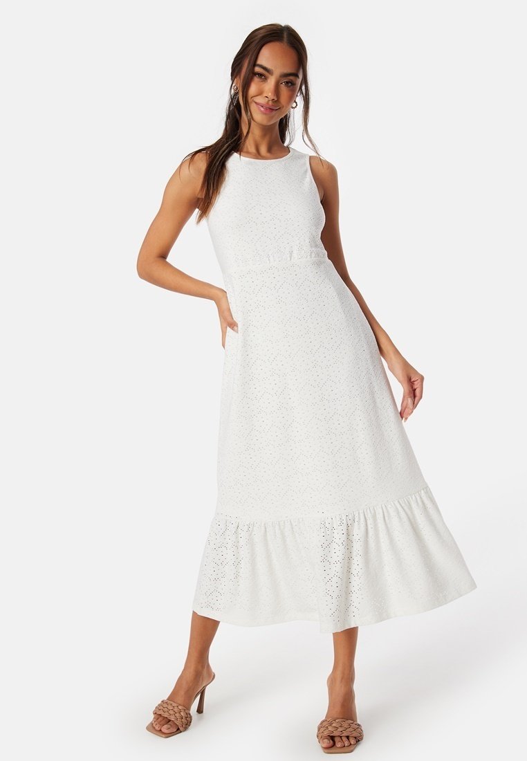 Vit midi-klänning med figursydd överdel och utsvängd nederdel. Har ögla-mönster och rak halsringning. Stylad med beige, flätade mule-tofflor.