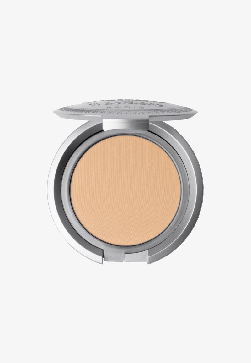 Kompaktpuder mit einer glatten beige Farbe. Rundes silbernes Etui mit einer strukturierten Oberseite, die ein erhabenes Design zeigt. Geöffnet, um das Puder zu enthüllen.