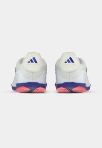 Zapatillas deportivas blancas con detalles en azul, parte superior de malla texturizada, cuello acolchado y suela de goma con tonalidad rosada. Presentan tres franjas azules en el talón.