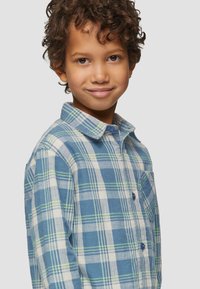 Geruite button-up shirt in blauw, groen en wit; gemaakt van lichtgewicht stof; heeft een kraag en een enkele borstzak.