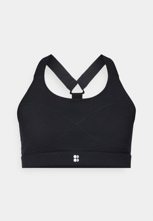 Črni športni modrc z dirkaškim hrbtnim delom, ki ima prekrivajoče se šive in logotip na spodnjem delu. Izdelan iz raztegljivega, teksturiranega materiala.