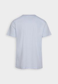 Camiseta de algodón azul claro con mangas cortas, cuello redondo y una textura suave. Diseño liso sin patrones ni acentos visibles.
