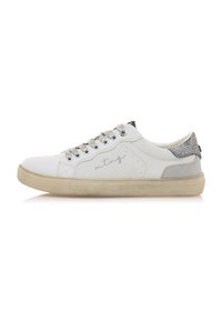 Zapatilla blanca con parte superior sintética texturizada, acentos plateados en el talón y parte trasera gris con patrones. Cuenta con punta redonda y delantero con cordones.