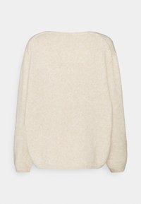 Pull en tricot de couleur crème vu de dos avec des manches longues et un col légèrement arrondi sur un fond clair.