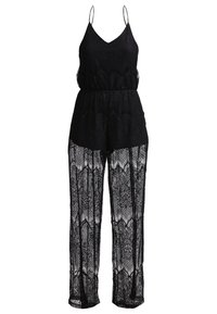 Jumpsuit sans manches en dentelle noire avec des bretelles spaghetti, taille cintrée, shorts opaques et jambes longues en voile à motif.
