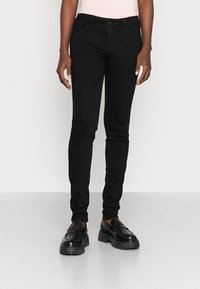 Svarte skinny jeans i en elastisk stoff med middels høy midje, med frontlommer, beltestropper og en slank passform ned til anklene.