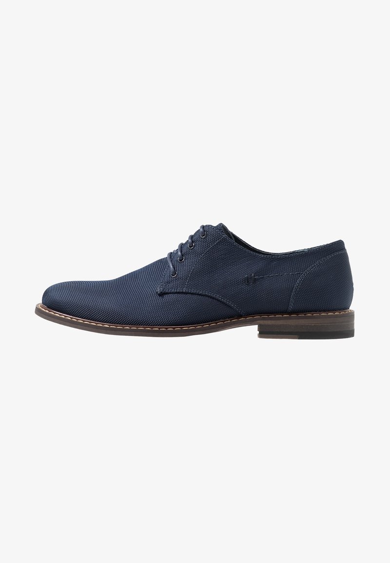 Chaussure Oxford homme bleu marine à lacets avec tige en tissu texturé et semelle marron, présentée de profil sur fond blanc.
