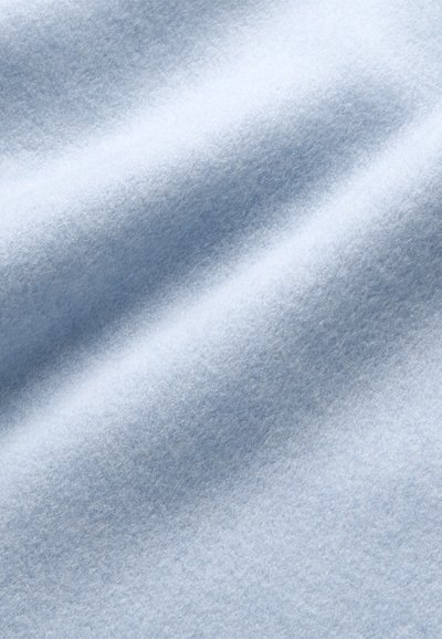 Lichtblau viltstof met een zachte textuur, zichtbare vezels en een lichte glans, met gladde, golvende plooien en een gelijkmatige kleurverdeling.