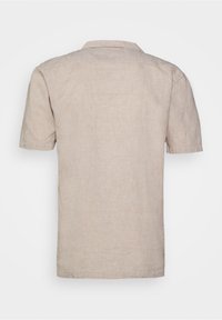 Chemise beige à manches courtes en lin ; dotée d'un col, d'un ourlet droit et d'une surface légèrement texturée. Design simple, sans motifs visibles.