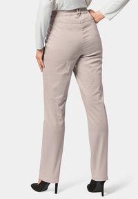 Pantalons beige clair en tissu doux, dotés d'une taille élastique, d'une coupe droite et d'une texture lisse.