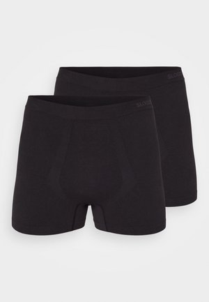 Schwarze Baumwoll-Boxershorts mit nahtlosem Design, featuring eine unterstützende Fronttasche und einen weichen Bund, präsentiert im Paar.