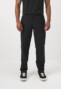 Pantaloni negri dintr-un material moale, cu un croi drept, buzunare standard și o talie confortabilă. Asortați cu adidași negri.