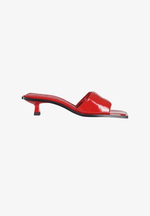 Mule rosso con punta aperta, tacco kitten basso e finitura lucida, vista di lato su sfondo bianco.