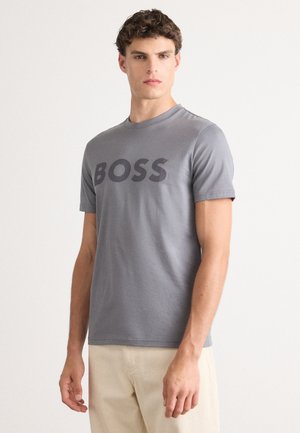 Grå kortermet t-skjorte i bomull, med et stort mørkegrått "BOSS"-logo på fronten, rund halsutskjæring og en tettsittende design.