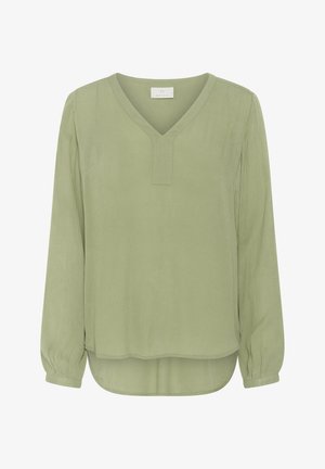 Blouse à manches longues vert clair avec un décolleté en V et une patte de boutonnage sans boutons ; ourlet arrière légèrement plus long ; tissu texturé avec une finition douce.