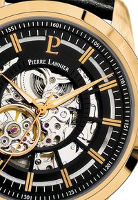 Montre squelette de Pierre Lannier avec un boîtier doré, un cadran noir, des mouvements mécaniques visibles, des aiguilles dorées et un bracelet en cuir noir.