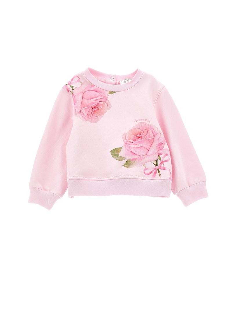 Rosa genser med blomstertrykk som har store akvarellroser og grønne blader. Rund hals, ribbestrikkede mansjetter og nederkant. Myk stofftekstur.