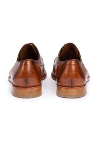 Bruine leren schoenen met een gladde afwerking, ronde neus en minimale stikdetails. Houten hak en rubberen zool voor grip.