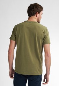 Olivengrøn kortærmet t-shirt lavet af bomuld, med rund halsudskæring og glat tekstur, synlig søm langs kanten.