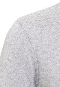 Nahaufnahme eines grauen Pullovers mit weichem Strickmuster, Rundhalsausschnitt und subtilen Nähten an der Schulterblende.