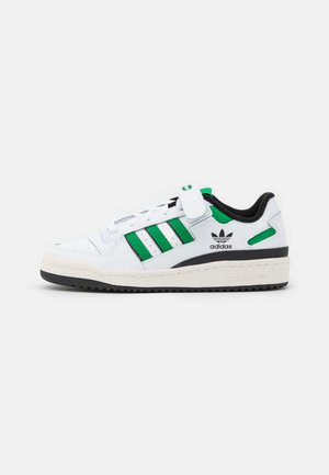 Białe skórzane sneakersy z zielonymi i czarnymi akcentami, trzema zielonymi paskami i rzepem. Posiadają teksturowaną gumową podeszwę.