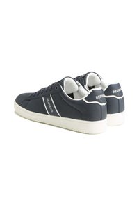 Zapatillas de hombre en color navy con acentos en blanco, fabricadas en material sintético suave, con puntera redonda, diseño de cordones y logotipo en el talón. Suela de goma para un buen agarre.