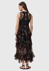 Black floral dress with layered ruffles, lace detailing on shoulders, and a keyhole back. Features a sheer, lightweight fabric.