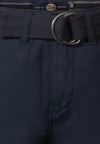 Pantaloni blu navy con una texture liscia, dotati di una cintura intrecciata con una fibbia a D in metallo e dettagli cuciti in vita.