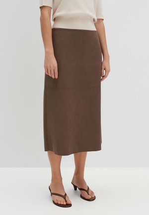 Gonna midi in suede marrone con forma dritta e cuciture sottili. Abbinata a sandali flip-flop neri per un look casual.