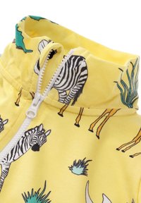 Geel ritsvest met een hoge kraag, voorzien van zwart-wit zebra print en groene plant ontwerpen. Gemaakt van een zachte katoenmix.